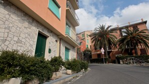 A multi-story building with a stone facade, green shutters, and balconies. - BLUE DIAMOND in the 5Terre-Cod. Citra 011019-LT-0241 (Monterosso al Mare)