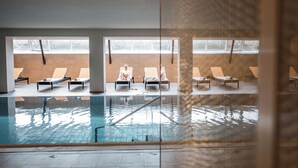 Una piscina con sillas de descanso y vistas al exterior.