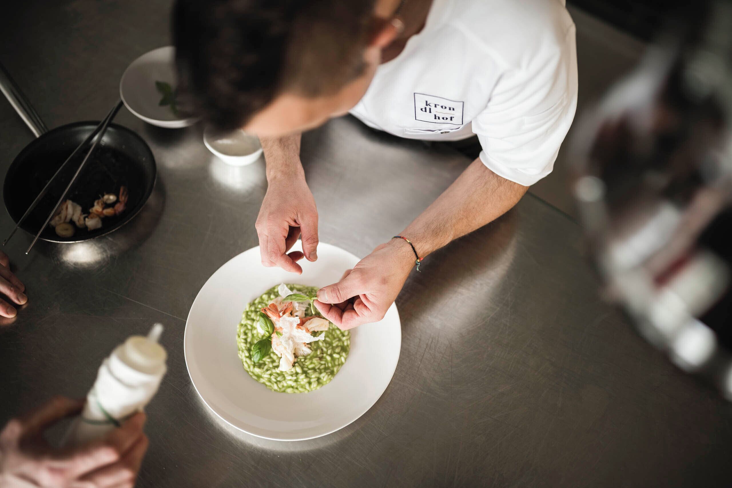 A person preparing food on a stainless steel table.