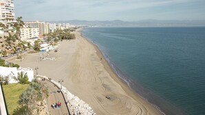 A beach with buildings and a clear sky. - DELUXE APARTMENT- BEACHFRONT, SWIMMING POOL, A/A, FREE WIFI AND PARKING (Torremolinos)