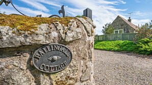 A stone sign with "Ballingall Cottage" engraved on it, a stone house with a green fence, and a gravel path leading to the house. - Beautiful, detatched 300 year old, fully renovated cottage with country views (Perth & Kinross)