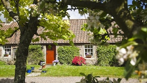 A stone house with a tiled roof, a wooden door, and a gravel driveway. - Beautiful, detatched 300 year old, fully renovated cottage with country views (Perth & Kinross)