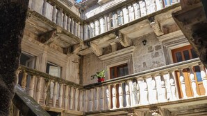 A courtyard with a stone staircase, a green door, and a balcony with ornate balustrades. - 3 bedroom villa, sea 5 minutes walk, private parking & garden, quiet location (Ulica Bana  Mazuranica)