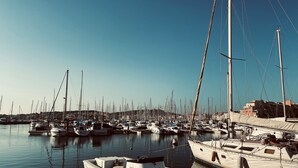 Un port de plaisance où sont amarrés différents types de bateaux, dont un bateau blanc sur lequel on peut lire les mots « CAP D’AGDE CAPITAIRERIE ».