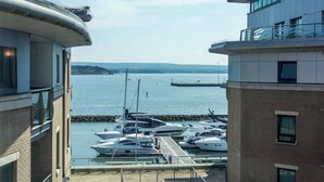 A marina with several yachts docked, a clear view of the water, and buildings with balconies overlooking the marina. - Jeanneau - Dolphin Quays Development on Poole Quay (Poole)