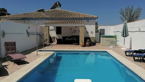A swimming pool with lounge chairs and a covered patio area. - Modern Villa, Private Pool, Wifi, Air Con, Central Location, Many Extras (Chiclana)