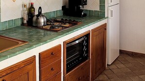 Una cocina con armarios de madera, estufa, microondas y salpicadero de azulejos.