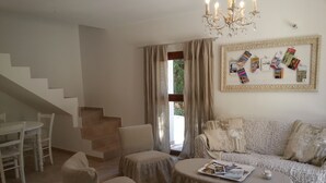 A living room with a staircase, a chandelier, a sofa, and a coffee table. - Charming house surrounded by vineyards and the Luberon countryside (Grambois)