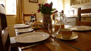 A breakfast table set with plates, glasses, and a pitcher of orange juice.