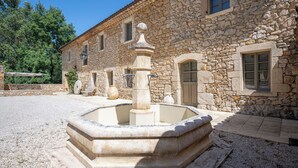 Ein Steinhaus mit einem Brunnen im Innenhof.