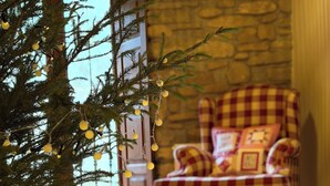 A cozy room with a wooden floor, a checkered armchair, and a Christmas tree with lights. - Country Cottage / Bilbao (Gordexola)