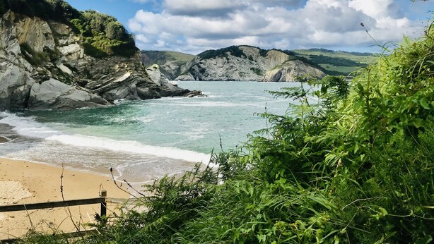 A coastal landscape with rocky cliffs, a sandy beach, and lush greenery. - Country Cottage / Bilbao (Gordexola)