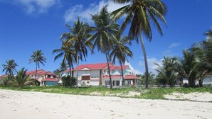 A beachfront hotel with multiple buildings, palm trees, and a sandy beach. - Luxury residence on plage des raisins clairs in saint-francois (Saint-François)