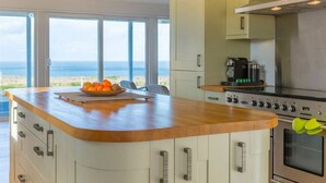 A kitchen with a wooden countertop, a coffee machine, and an oven.