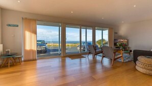 A spacious living room with a large sliding glass door leading to a parking area.