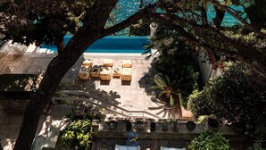 A pool area with lounge chairs and a view of the sea. - Extraordinary seafront villa with pool for up to 9 people (Lozica)