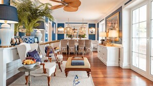 A spacious living room with a large window, a dining area with wicker chairs, and a ceiling fan. - Extraordinary seafront villa with pool for up to 9 people (Lozica)