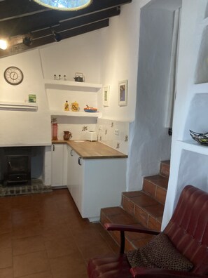 A kitchen with white cabinets, a wooden countertop, and a red chair. - Casita Escondida (Hidden Cottage) A private hidden gem with fantastic views... (Comares)