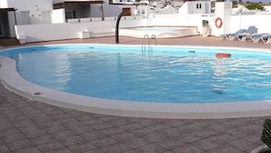 A swimming pool with a tiled deck, a lifebuoy, and lounge chairs. - La Concha Beach. 2Dormitorios wifi and communal pools (Playa Honda)