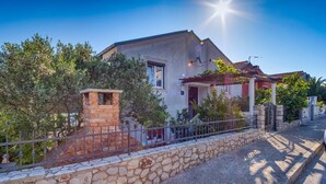 Une maison à deux étages avec un mur en pierre et une clôture en métal.