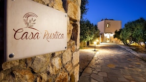 Un muro di pietra con un cartello che riporta la scritta 'Casa Rustica'.