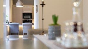 Una cocina moderna con comedor, que incluye una lámpara, una planta en maceta y una botella decorativa.