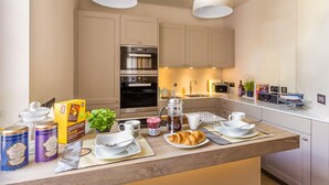 Una cocina moderna con una isla central, electrodomésticos de acero inoxidable y una zona para desayunar.