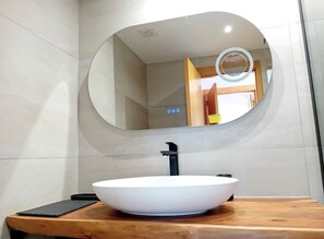 Een bad/douchecombinatie, een haardroger, een bidet, handdoeken