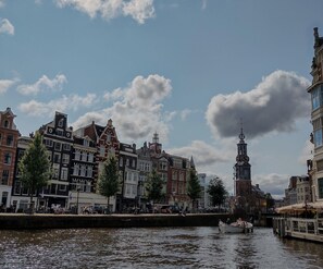 Un canal avec un bateau, des bâtiments historiques et une tour.