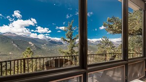 Ein Balkon mit Blick auf Berge und Bäume.