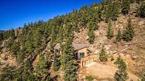Eine Bergingerhütte mit einstöckigem Bau, umgeben von dichtem Wald und felsigem Gelände.