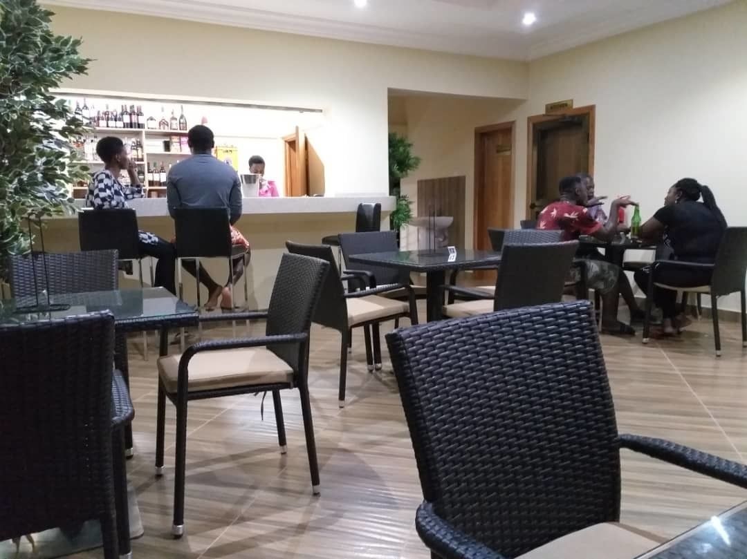 A restaurant with a bar area, tables, and chairs.