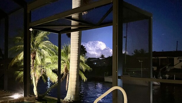 A pool area with a view of palm trees and a moon in the sky. - Villagoona, waterfront, infinity pool, dir.access to the Gulf of America (Cape Coral)