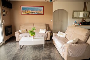 A living room with a beige sofa set, a white coffee table, and a potted plant. - farm house at the foot of the mountains and 1 kilometer from Espelette center (Espelette)