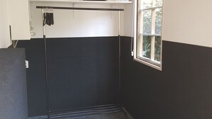 A room with a black and white wall, a window, a coat rack, and a shelf with folded clothes. - Attractive detached house with all amenities and garden / terrace, lots of privacy! (Amerongen)