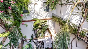 A courtyard with a white building, a checkered door, and a staircase.