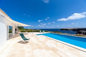 A swimming pool with a view of the sea, a covered patio, and a few lounge chairs. - Panoramic Sea Views, 20m easy access to the sea, ideal for snorkelling (Es Mercadal)