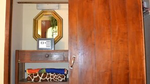A wooden wardrobe with a mirror and a small shelf with a giraffe-patterned pillow. - Wacos House in the heart of Varadero (Varadero)