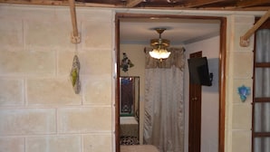 A narrow hallway with a wooden door, a ceiling fan, and a wall-mounted television. - Wacos House in the heart of Varadero (Varadero)