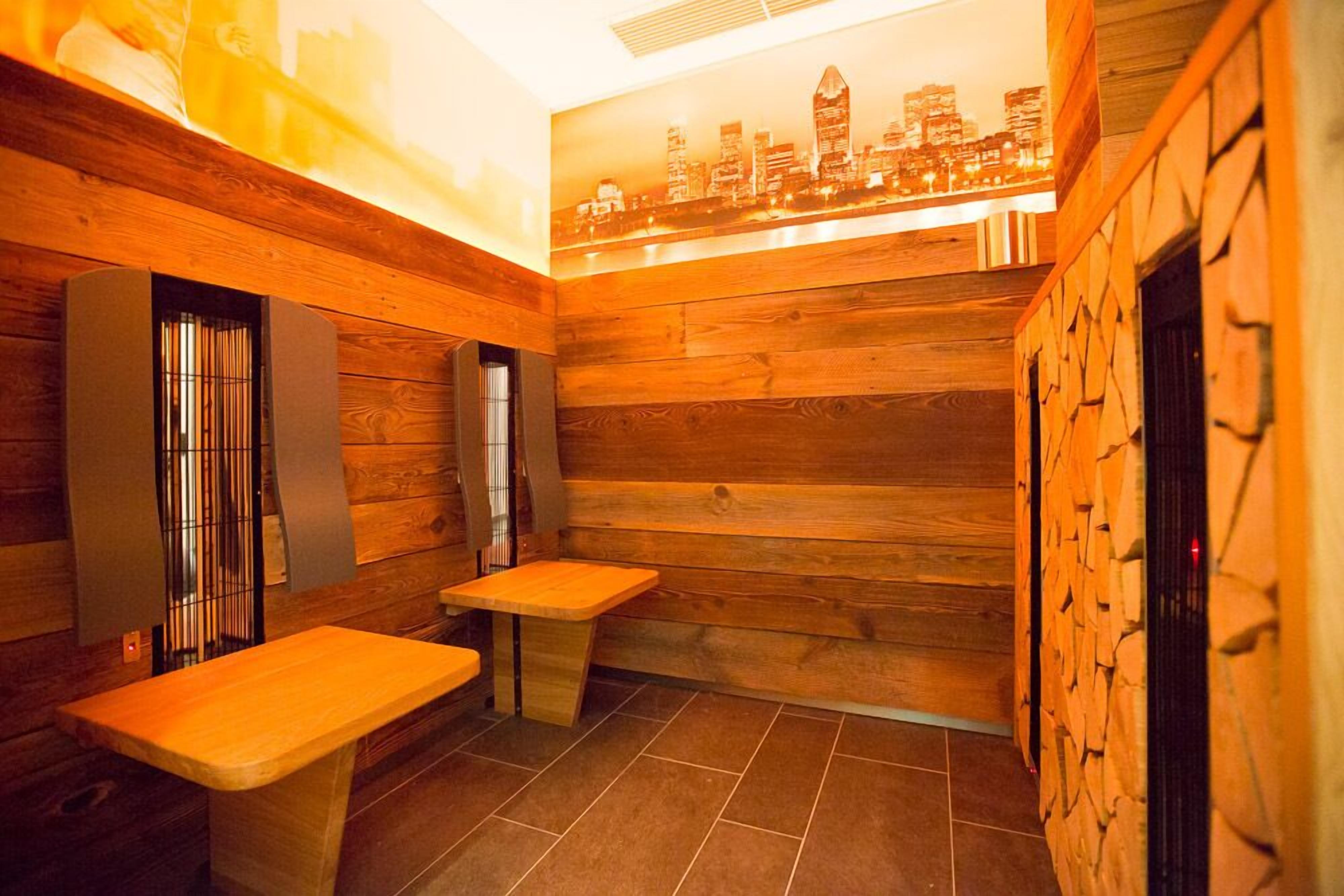 A sauna room with wooden walls and a cityscape mural.