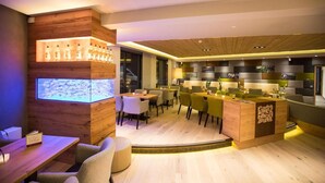 En moderne restaurant med trædetaljer, et barområde og et digitalt display.