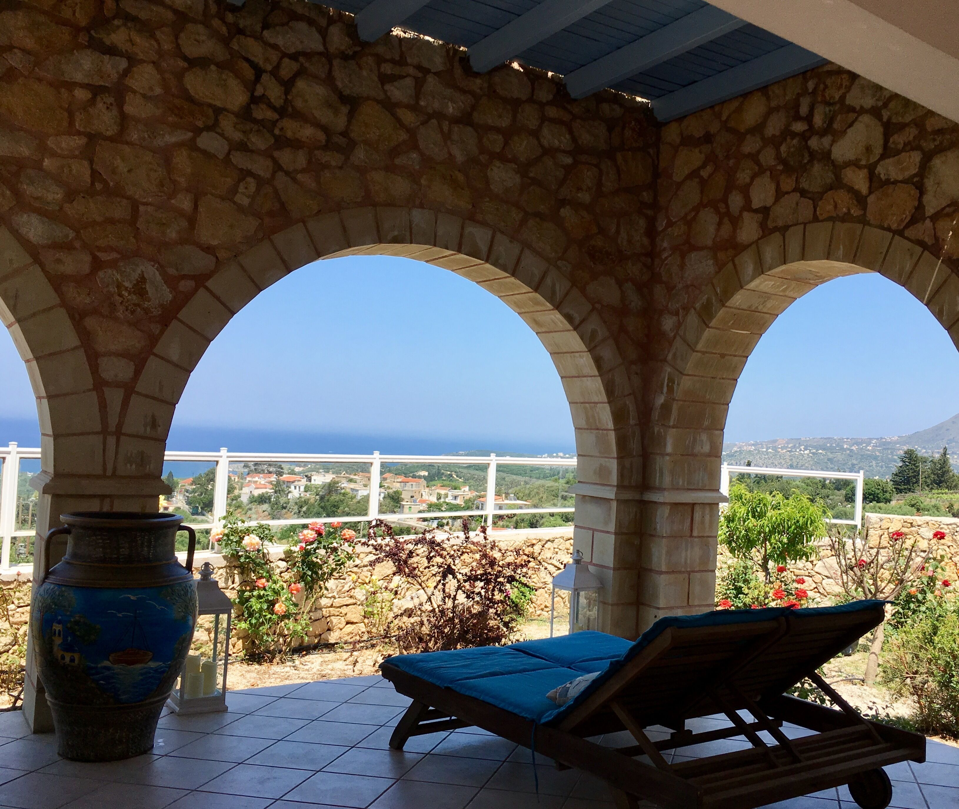 Ein mit Steingewölben ausgestatteter Sitzbereich im Freien mit Blick auf das Meer und einem gefliesten Boden.