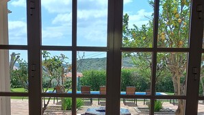 A view through a glass door with a patio area, including a fire pit and outdoor furniture. - Large villa - 6 rooms, garden and swimming pool in Budens, near Salema beach.  (Budens)