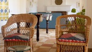A room with two wicker chairs, a table with candles, and a tiled floor. - Large villa - 6 rooms, garden and swimming pool in Budens, near Salema beach.  (Budens)