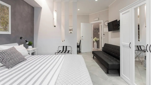 A modern bedroom with a bed, a sofa, and a TV. - Interior 1 Ciampino Rome with private balcony (CIAMPINO)