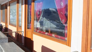 A building with large windows, wooden frames, and a red curtain. - APARTMENT WITH IDEAL PANORAMIC VIEW FOR FAMILIES (Sestriere)