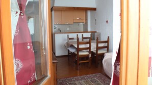 A compact kitchen with wooden cabinets, a dining table, and chairs. - APARTMENT WITH IDEAL PANORAMIC VIEW FOR FAMILIES (Sestriere)