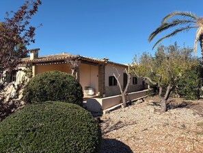 A Mediterranean-style villa with a tiled roof, stone walls, and a well-maintained garden.