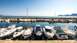 A marina with various boats docked, calm water, and a clear sky. - Luxury house on the front line of the sea (Son Serra de Marina)