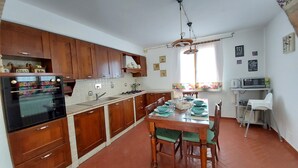 A kitchen with wooden cabinets, a stove, and a dining table set for four.